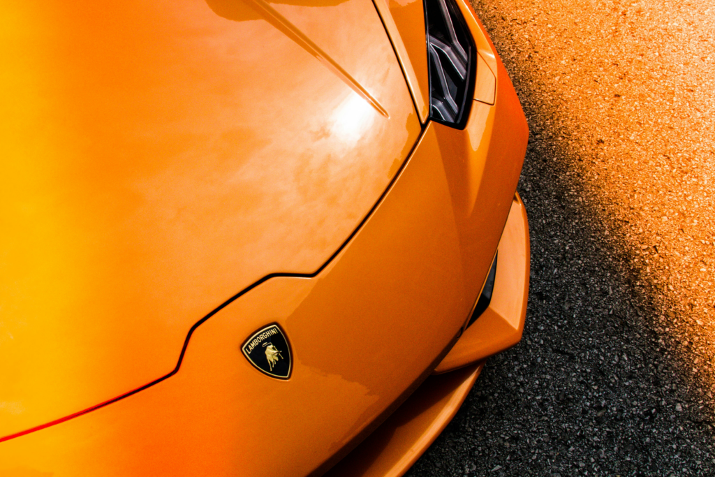 Blick von vorne und von oben auf die linke Seite der Motorhaube eines orangen Lamborghini Huracán