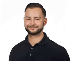 Ein lächelnder Mann in schwarzem Polohemd vor weißem Hintergrund.