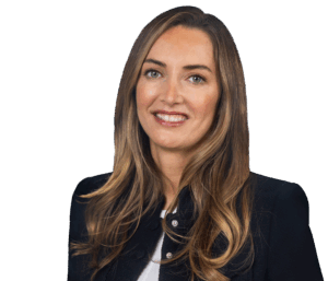 Porträt einer lächelnden Frau mit langen, glatten Haaren und dunklem Blazer vor neutralem Hintergrund.